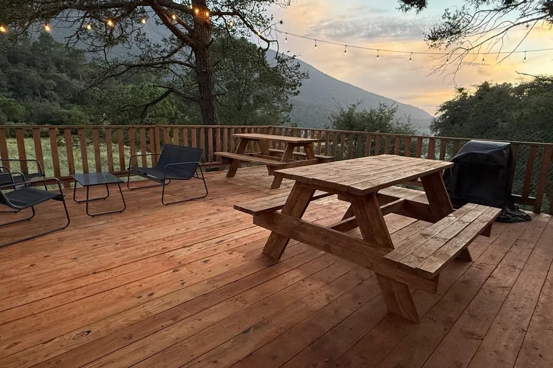 Terraza MORET con mesas de picnic y vista a la montaña al atardecer